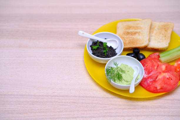 Healthy breakfast with toast bread guacamole olive paste tomatoes and cucumbers