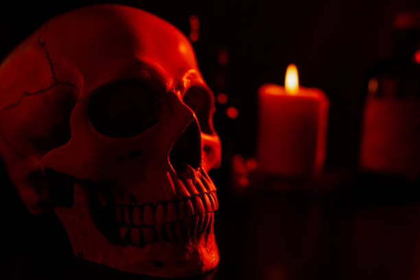 Halloween food table decoration for scary event with candy, pop corn, candles and skull