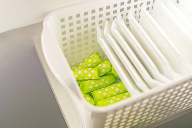 feminine hygiene products: tampons and pads in a basket. - padding imagens e fotografias de stock