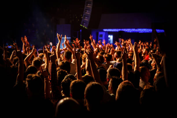 istock People at a public event. Crowd with raised hands at a concert. 1346361149