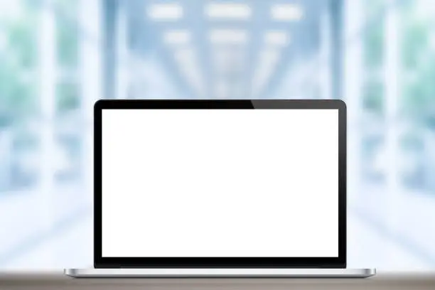 Laptop with blank screen on office background
