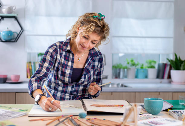 istock Attractive woman doing a drawing with a pencil in the notebook 1346365292