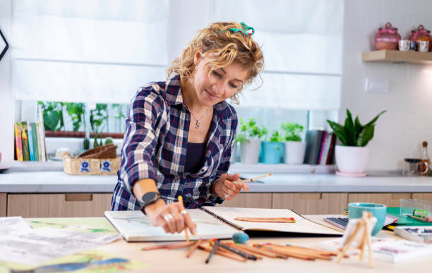 istock Attractive woman doing a drawing with a pencil in the notebook 1346365298