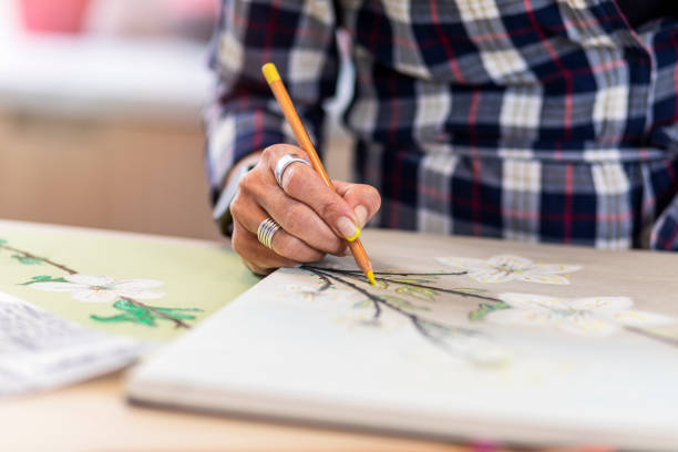 istock Close-up of a woman's hand holding a pencil and drawing on a notebook 1346365335