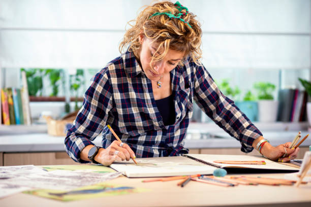 istock Attractive woman doing a drawing with a pencil in the notebook 1346365339
