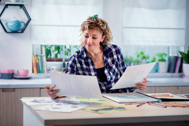 istock Attractive woman doing a drawing with a pencil in the notebook 1346365368
