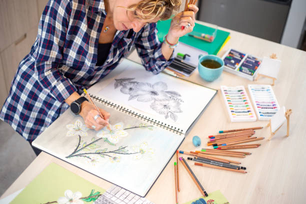 istock Attractive woman doing a drawing with a pencil in the notebook 1346365396