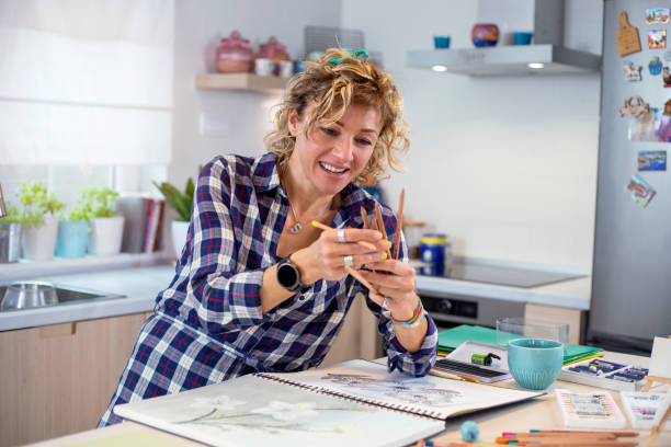 istock Attractive woman doing a drawing with a pencil in the notebook 1346365416