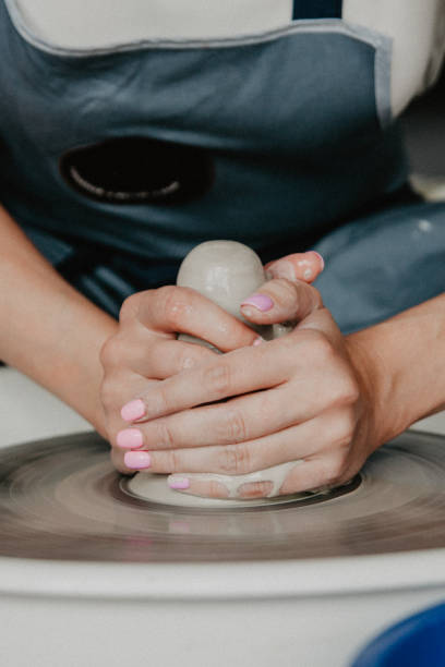 Tworzenie słoika lub wazonu z białej gliny z bliska. Kobiece ręce robiące gliniany dzbanek – zdjęcie