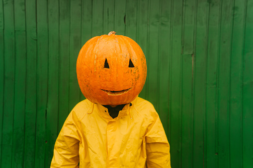 Photo of a men with a pumpkin on the head, ready for the Halloween.