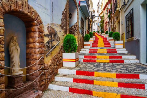 узкий переулок украшен флагом испании на ступенях. кальпе аликанте. - spain architecture landscape non urban scene стоковые фото и изображения
