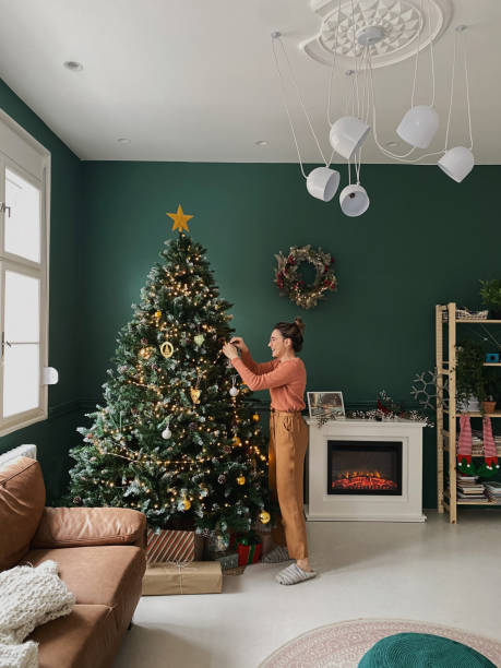 istock Young woman decorating a Christmas tree 1346370996