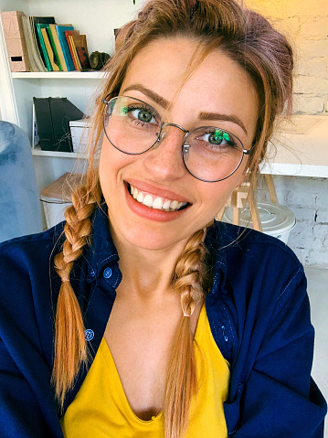 Selfie of a young, smiling woman at home