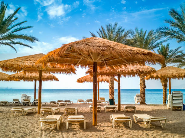 Resting facilities on sandy beach of the Red Sea in Eilat Concept of blessing vacation. Relaxing and water sport facilities on sandy beach in Eilat - famous tourist resort and recreation city in Israel akaba stock pictures, royalty-free photos & images