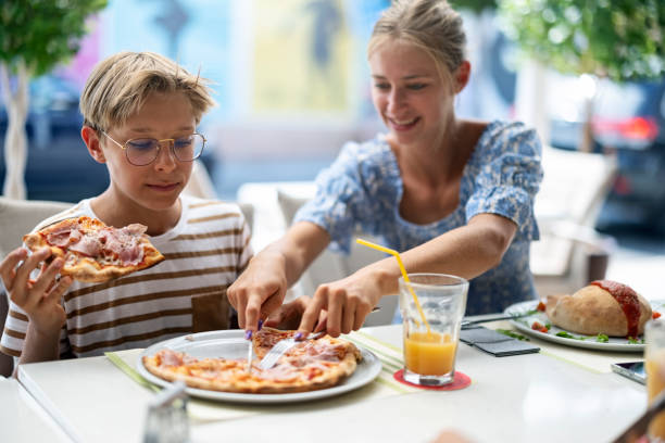 istock Teenagers having pizza lunch in outdoors restaurant 1346373513