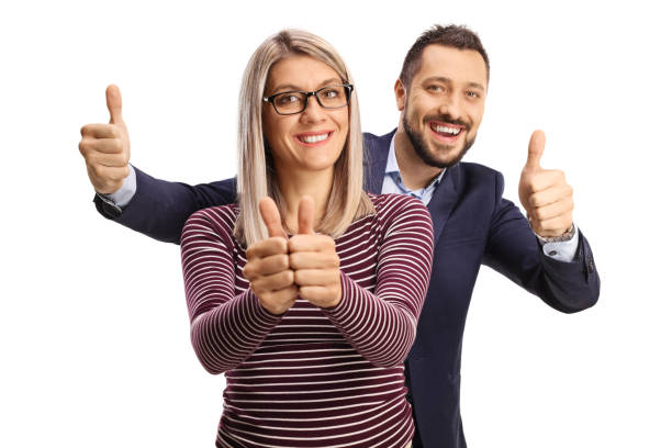 man standing behind a blond woman and gesturing thumbs up - thumbs up business people isolated imagens e fotografias de stock