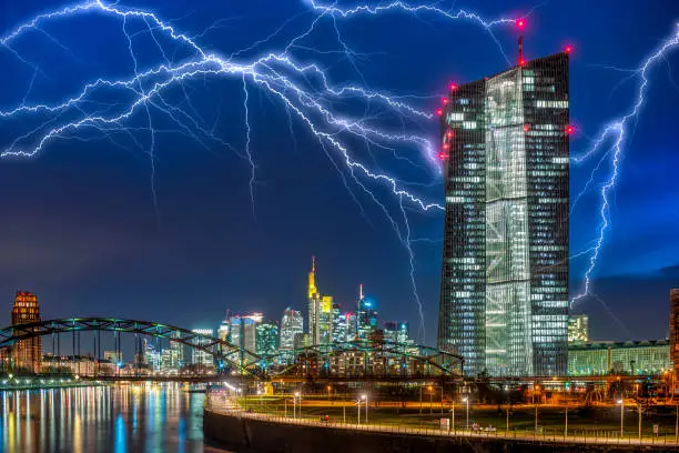 The ECB (European Central Bank) in Frankfurt am Main in front of the night sky with lightning strikes