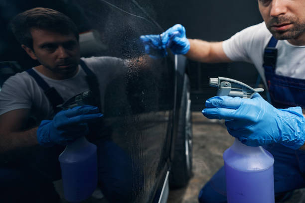 istock Car mechanic using cleaning spray on automobile door 1346375679