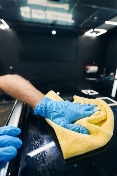 istock Male technician cleaning car roof surface with rag 1346375745