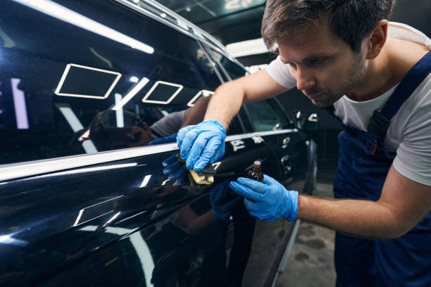 istock Attentive worker smearing blemishes on auto surface with ceramic coating 1346375994