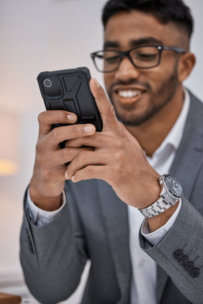 istock Shot of a young businessman using a cellphone while working in an office 1346379485
