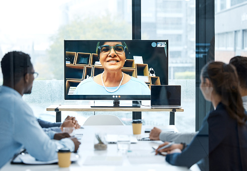 Shot of a group of businesspeople having a video call with a colleague in an office