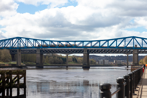 A train crossing a bridge over the river tyne on a sunny winters day.