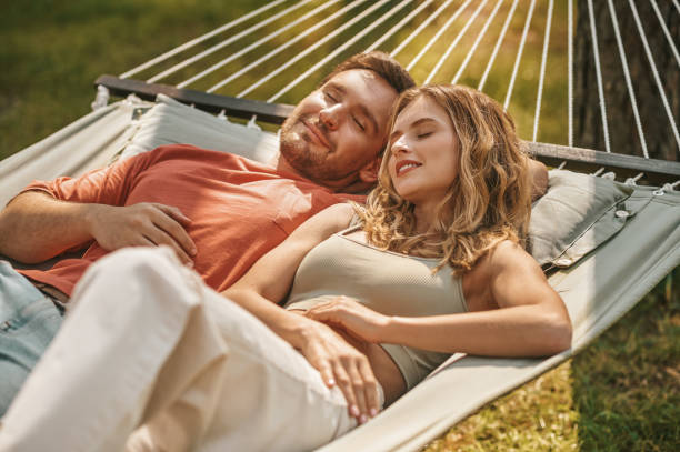istock Man and woman with closed eyes lying on hammock 1346393693