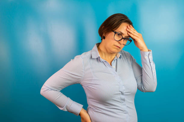 istock hopeless woman suffering from depression having nervous breakdown holding her head on isolated background, copy space. Depressed woman feeling lonely tired and worried suffering depression in mental health, loneliness and isolation concept. 1346395105