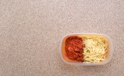 Leftover spaghetti in plastic container with copy space