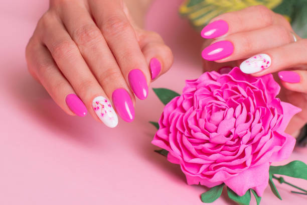 istock Beautiful female hands with pink manicure, peonies design 1346397306