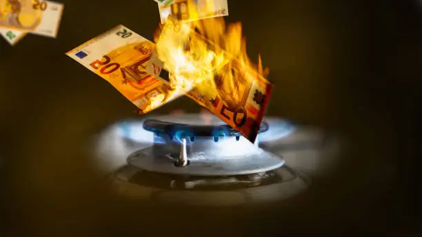 gas price increase, euro banknotes burn in the gas flame, symbolic concept for rising energy costs, money in the fire, close-up, higher expensive rate for energy