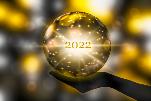 golden crystal ball in a hand, prediction for 2022, brights stars and sparks on abstract shiny background golden crystal ball in a hand, prediction for 2022, brights stars and sparks on abstract shiny background fortune telling stock pictures, royalty-free photos & images