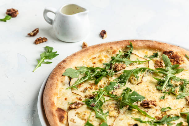 istock Pear pizza with blue cheese, walnut and arugula. Delicious pizza. top view 1346400842