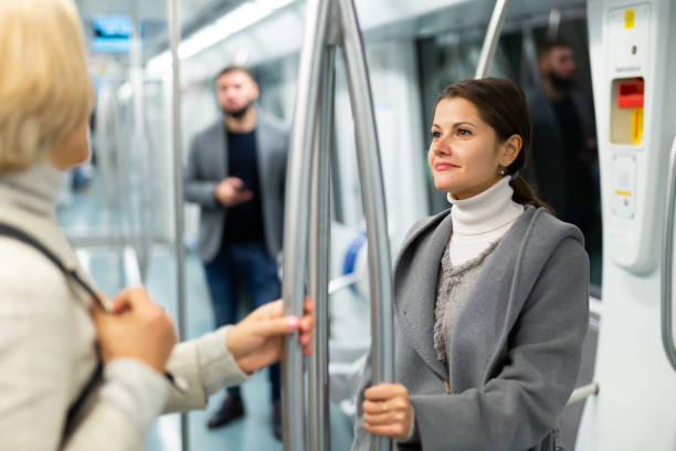 istock Two women passengers talking in subway car on way to work 1346401871
