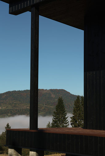 View of foggy valley from modern wooden black house