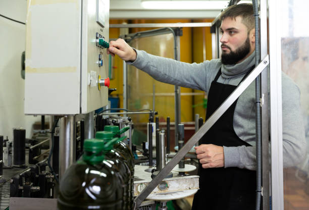istock Guy pouring olive oil in plastic bottles 1346402900