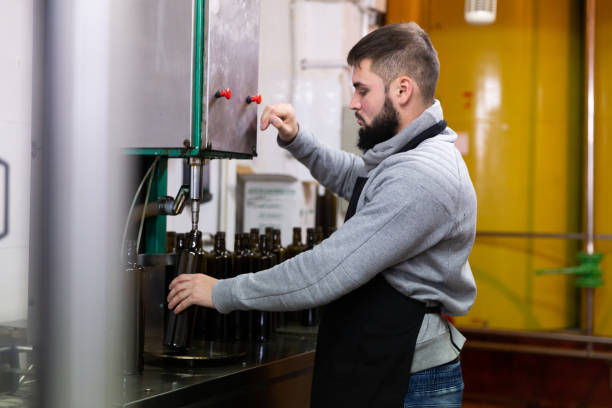 istock Young man working on olive oil bottling line 1346402905