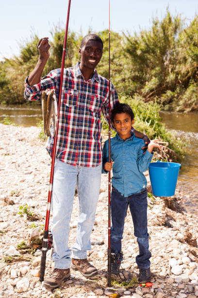 istock Man and boy with bucket of catch 1346403015