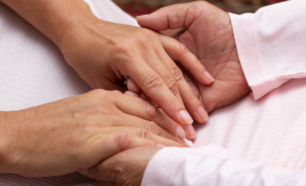 istock Old and young holding hands on light background, closeup 1346403047