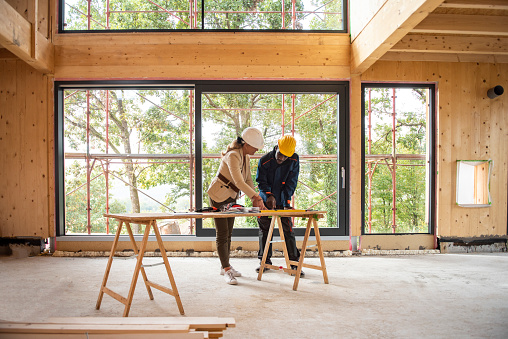 Female architect and construction worker looking at plans
