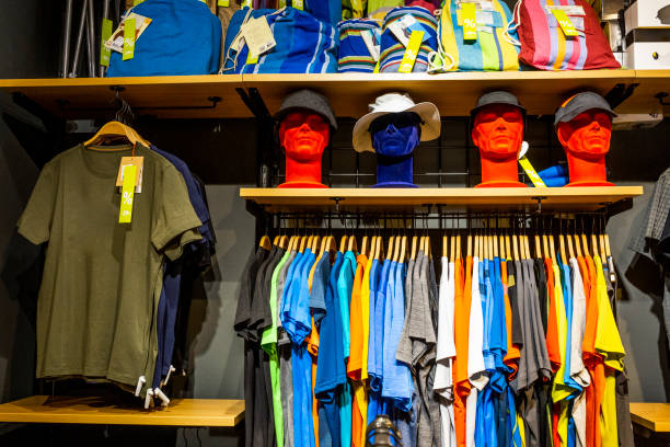 T-shirts, hats and other mountaineering and hiking equipment seen in an outdoor shop ready and lined up for customers.