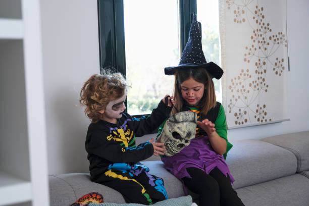 istock Children dressed up for Halloween by putting on a skull mask 1346406857