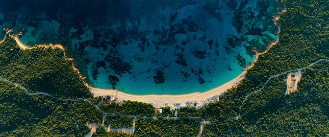 View from above, stunning aerial view of a white sand beach bathed by a turquoise water. Long Beach, Liscia Ruja, Sardinia, Italy.