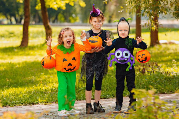 istock Happy Halloween. three running kids with a basket for sweets 1346413435