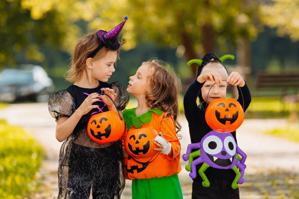 istock Happy Halloween. three running kids with a basket for sweets 1346413446