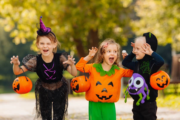 istock Happy Halloween. three running kids with a basket for sweets 1346413478
