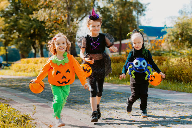 istock Happy Halloween. three running kids with a basket for sweets 1346413609