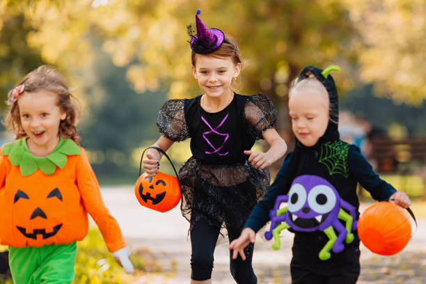 istock Happy Halloween. three running kids with a basket for sweets 1346413663