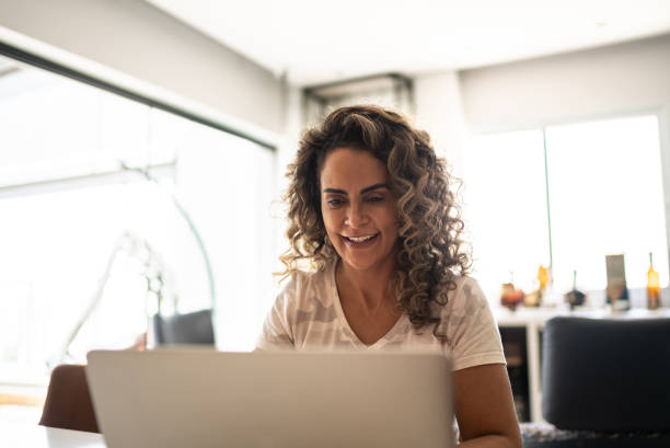 istock Mature woman using laptop at home 1346413670